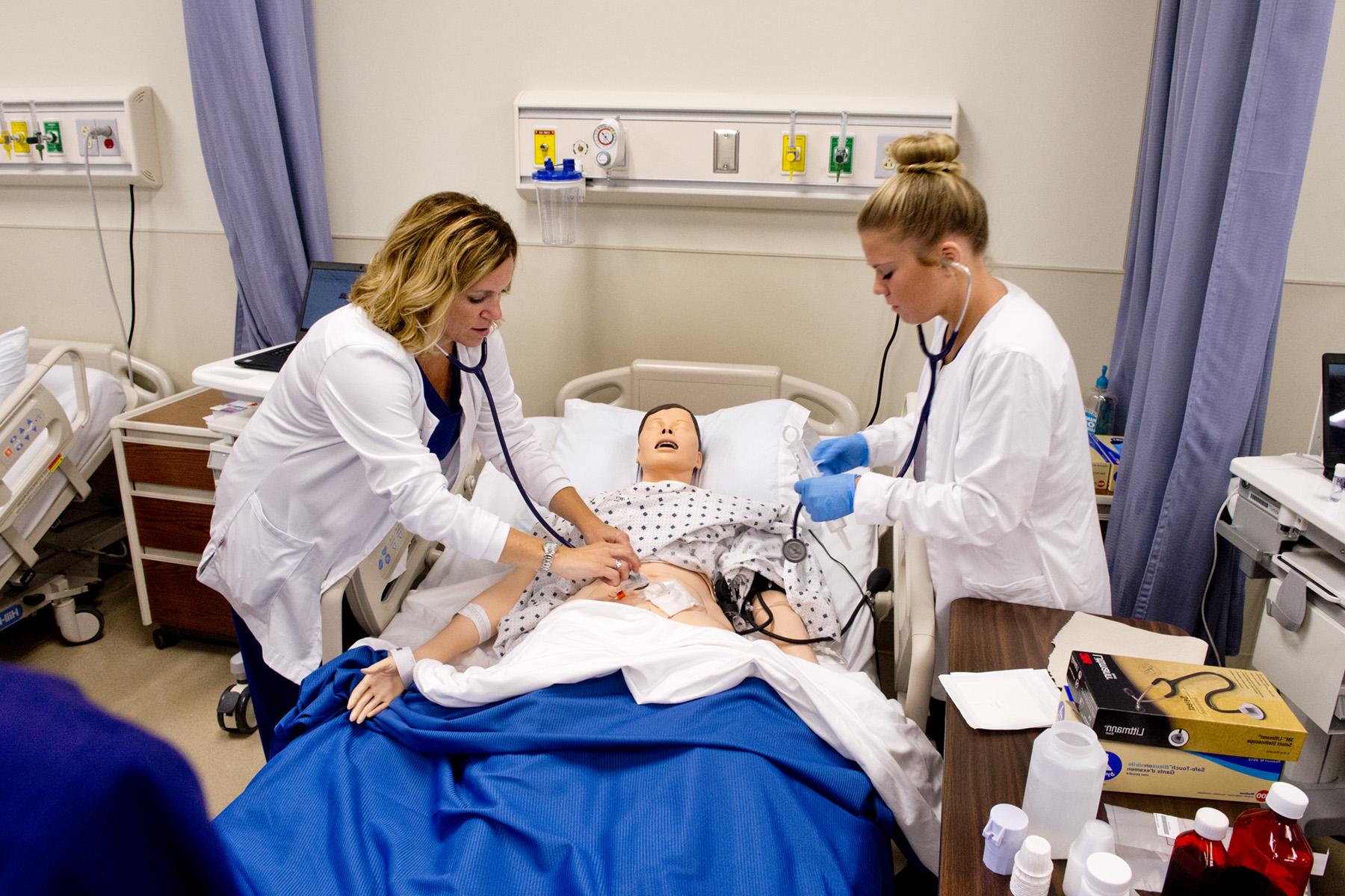 Nursing students and professor going over a project 